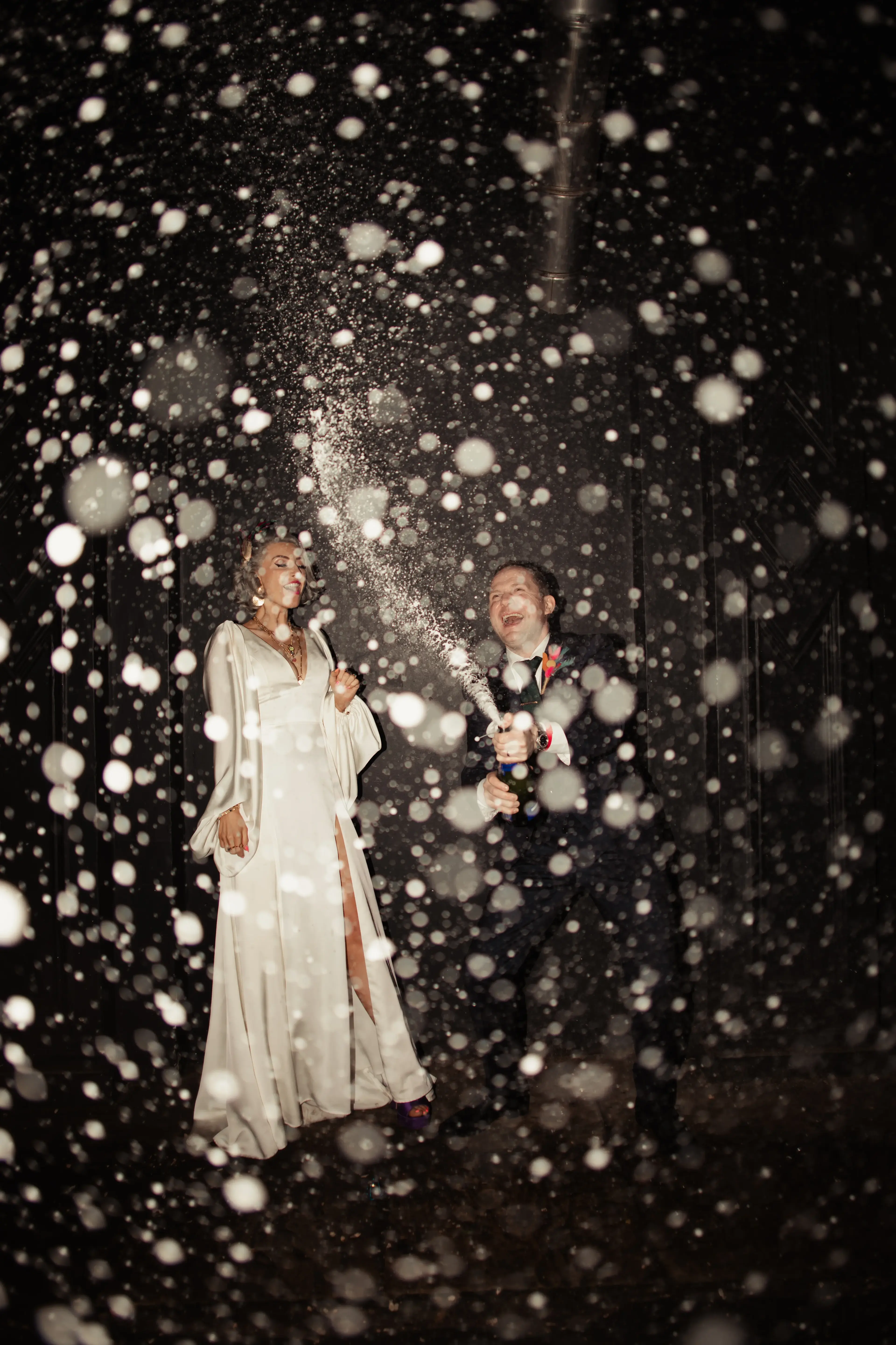 Bride and groom champagne spray outside a London pub wedding reception