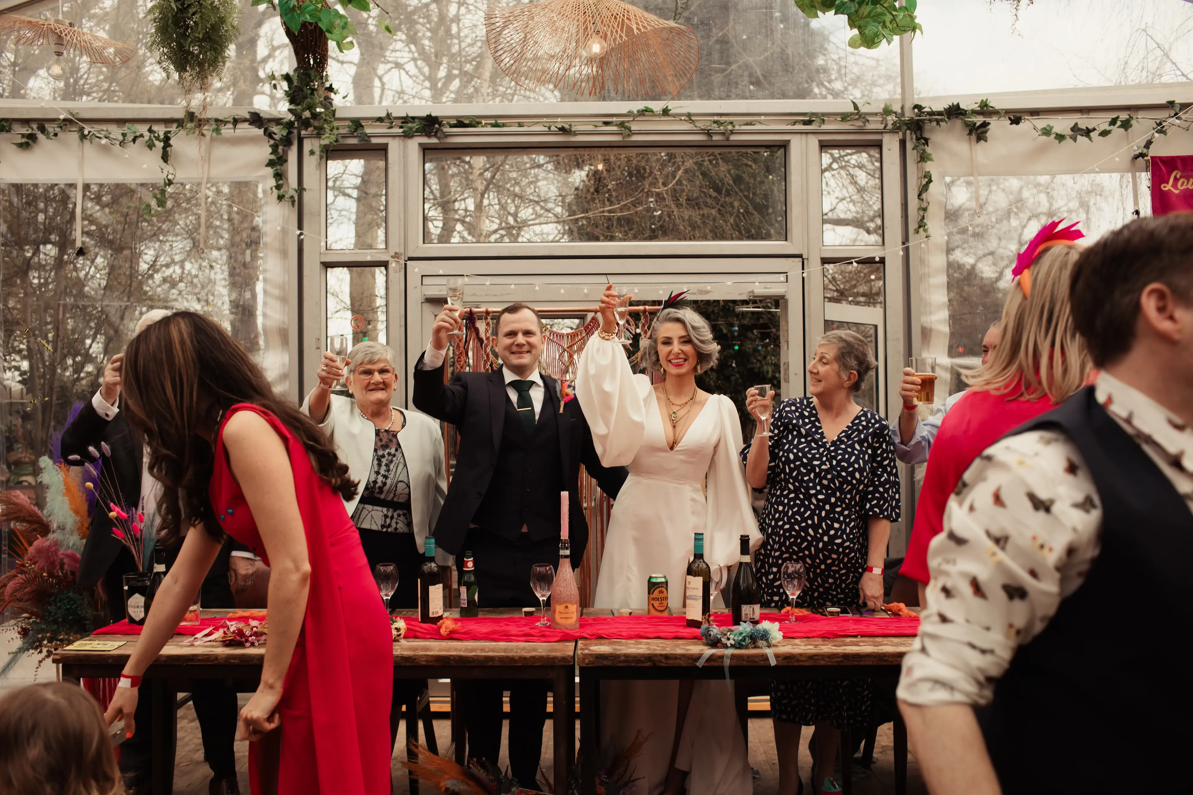 Bride and groom raise their glasses during wedding speeches, London