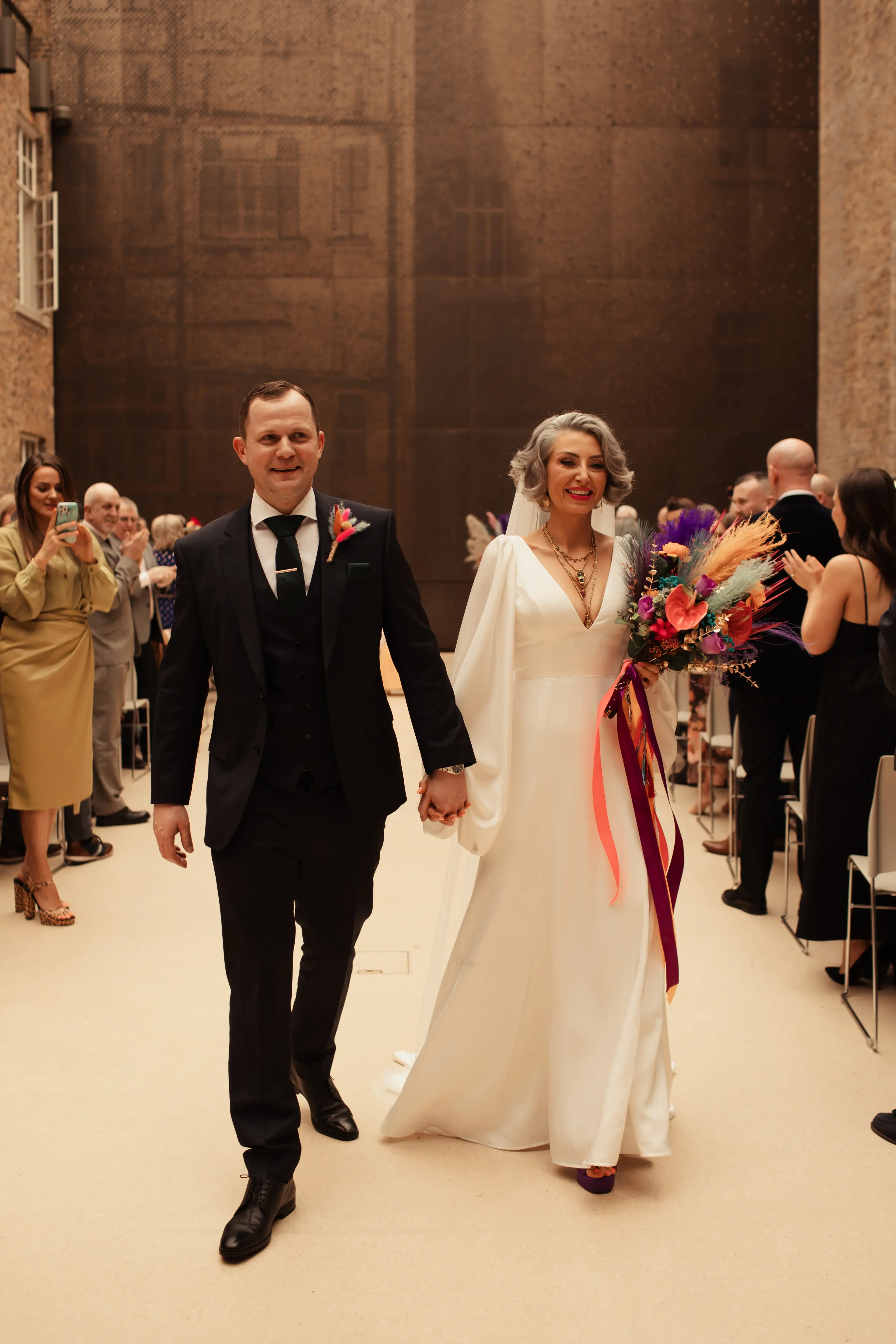 Bride and groom walking down the aisle out of Hackney Town Hall