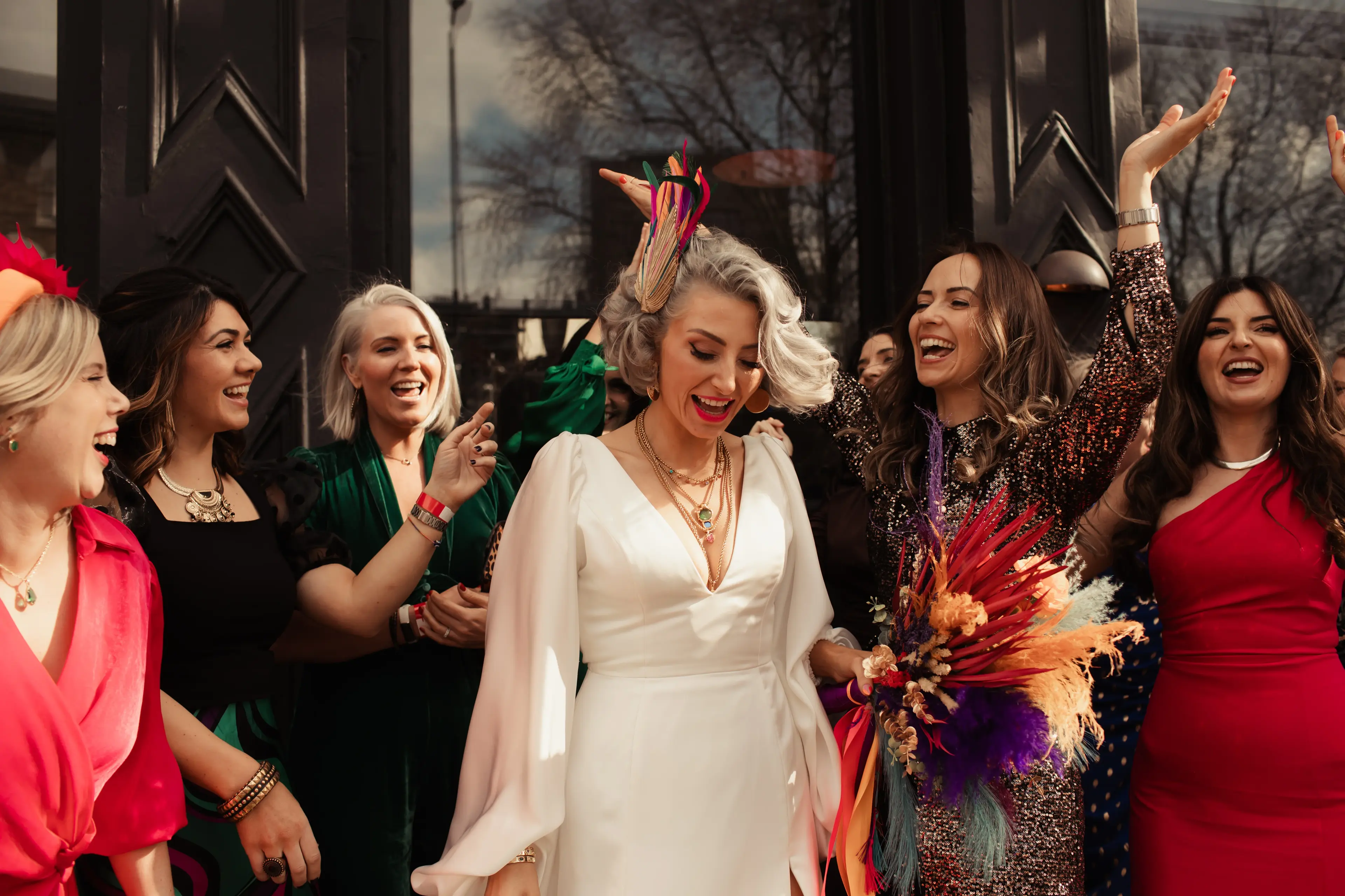 Bride surrounded by friends outside a London pub wedding reception