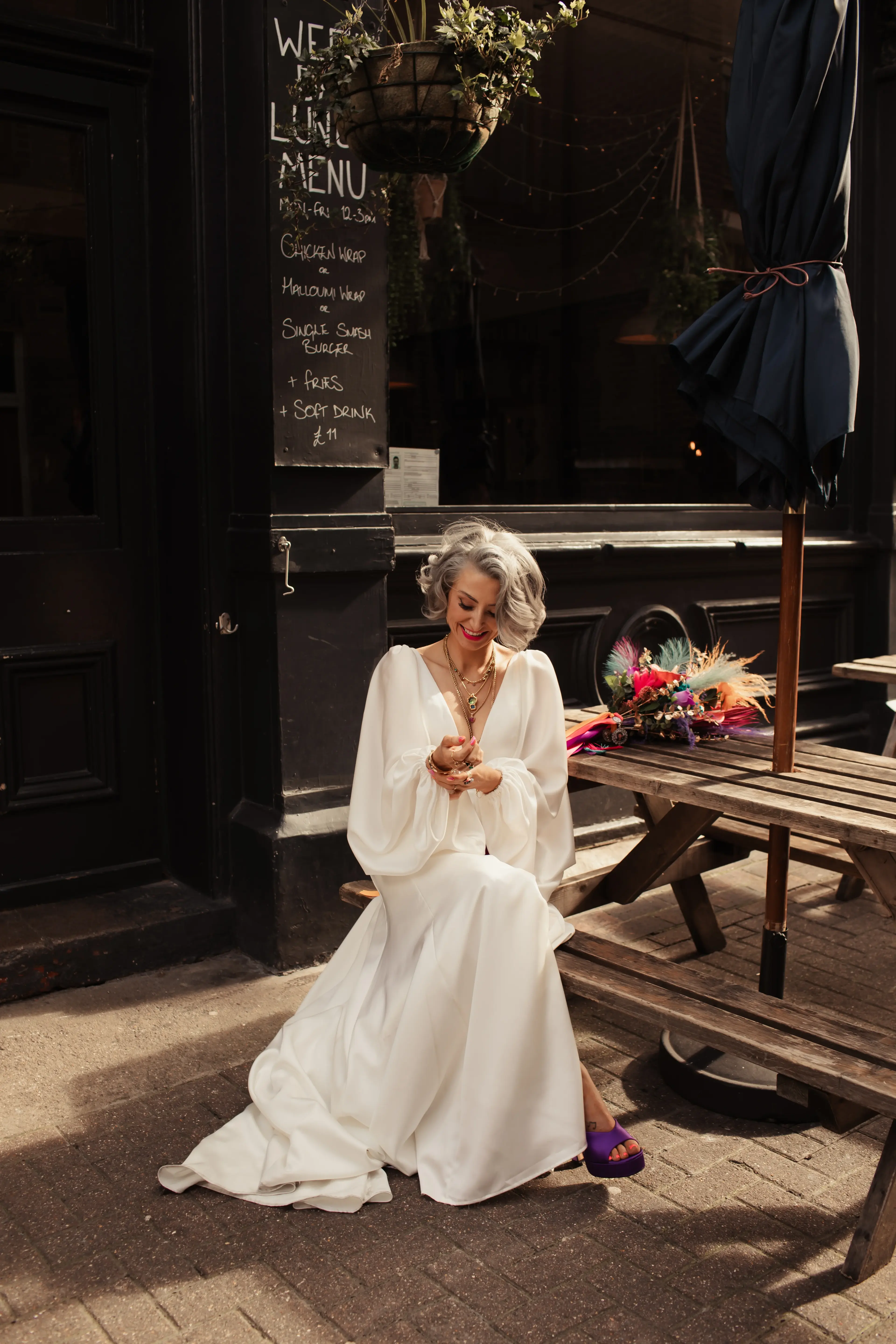 Newly married bride sat on a picnic bench in Hackney, London