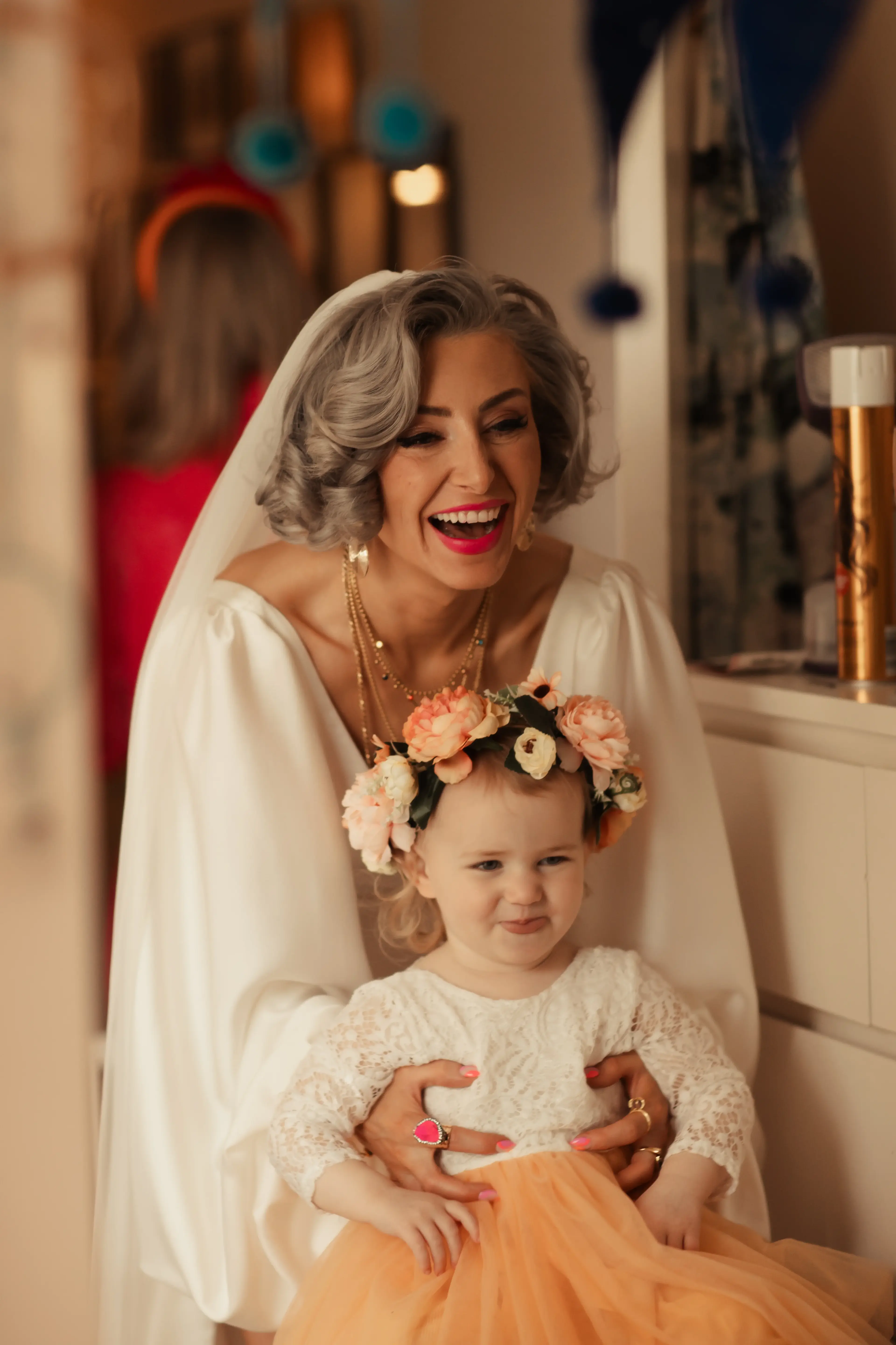 A bride having a laugh with a flower girl