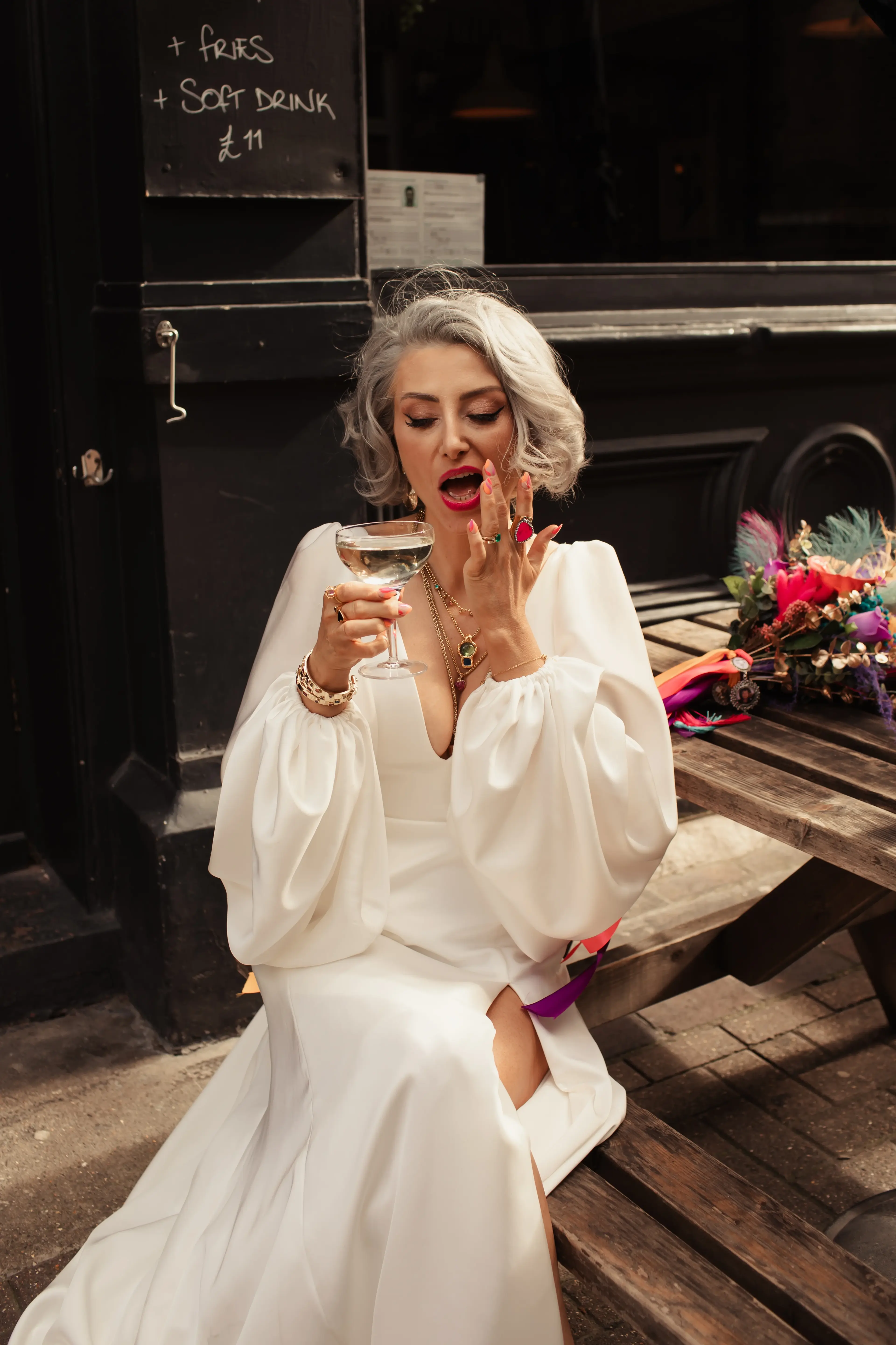 Newly married bride sat enjoying a drink outside People's Park Tavern in Hackney, London