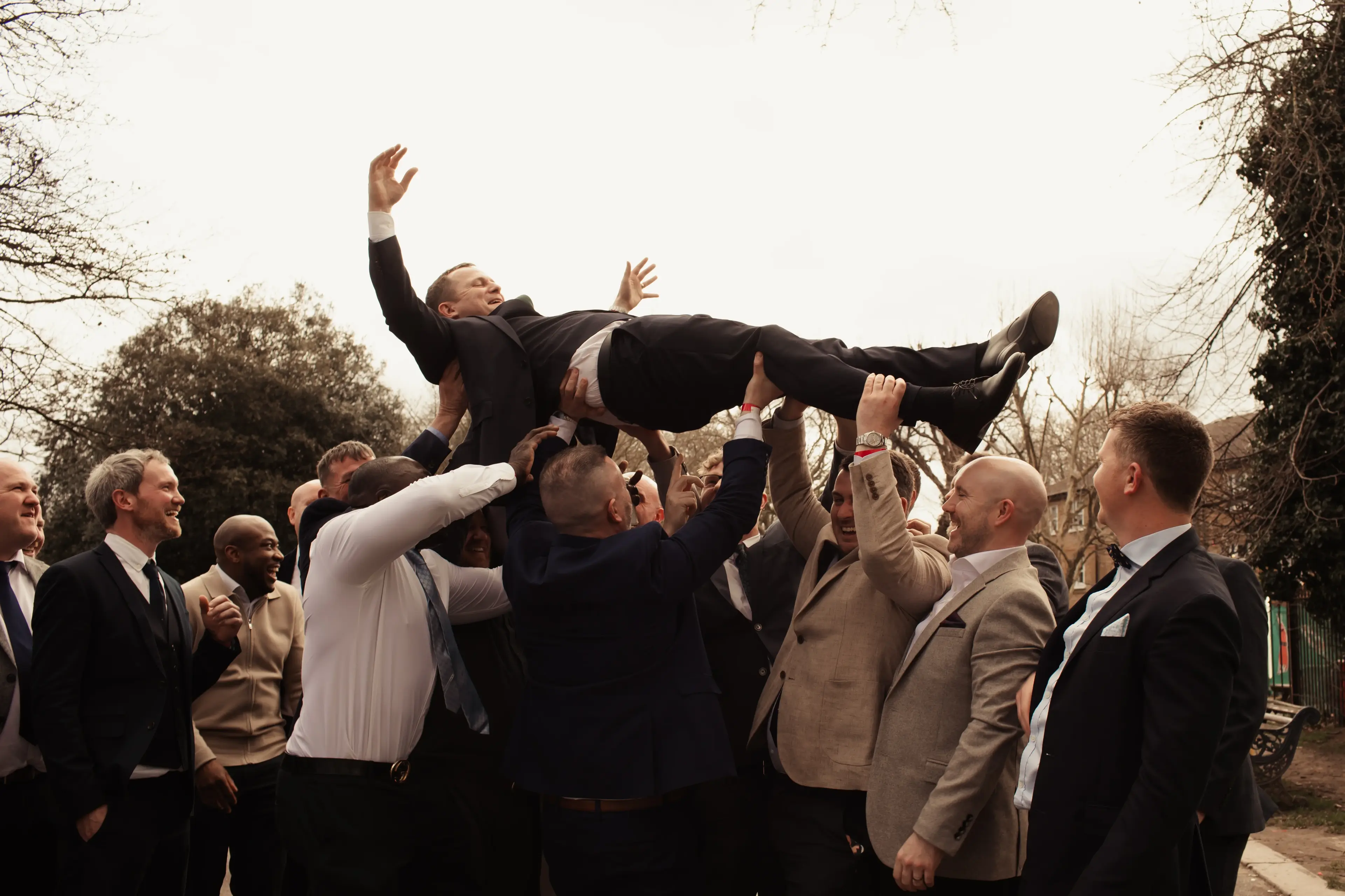 Groom being raised into the air by some wedding guests in London