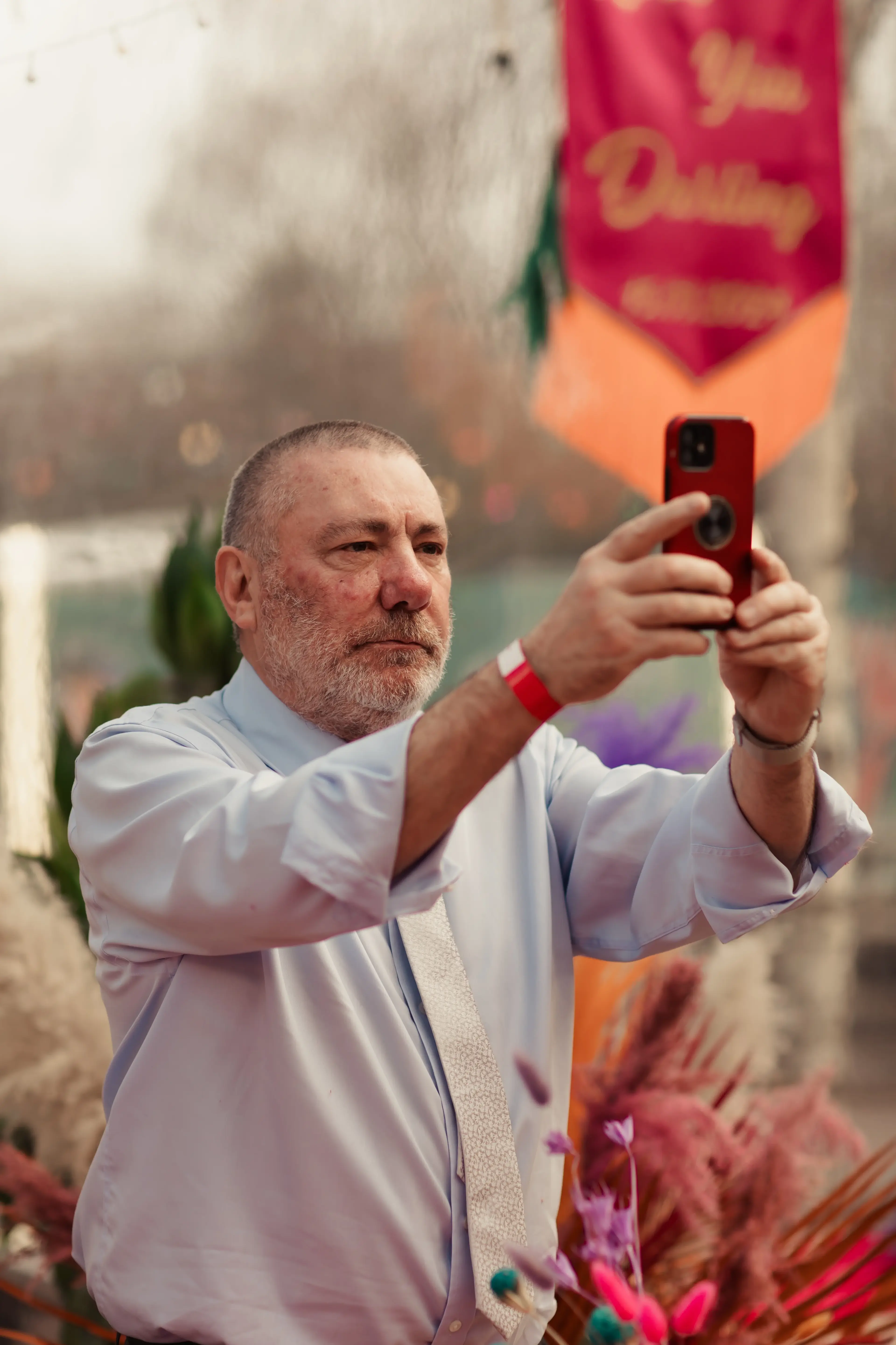 A guest making a memory on his phone at a wedding reception in the People's Park Tavern, Hackney