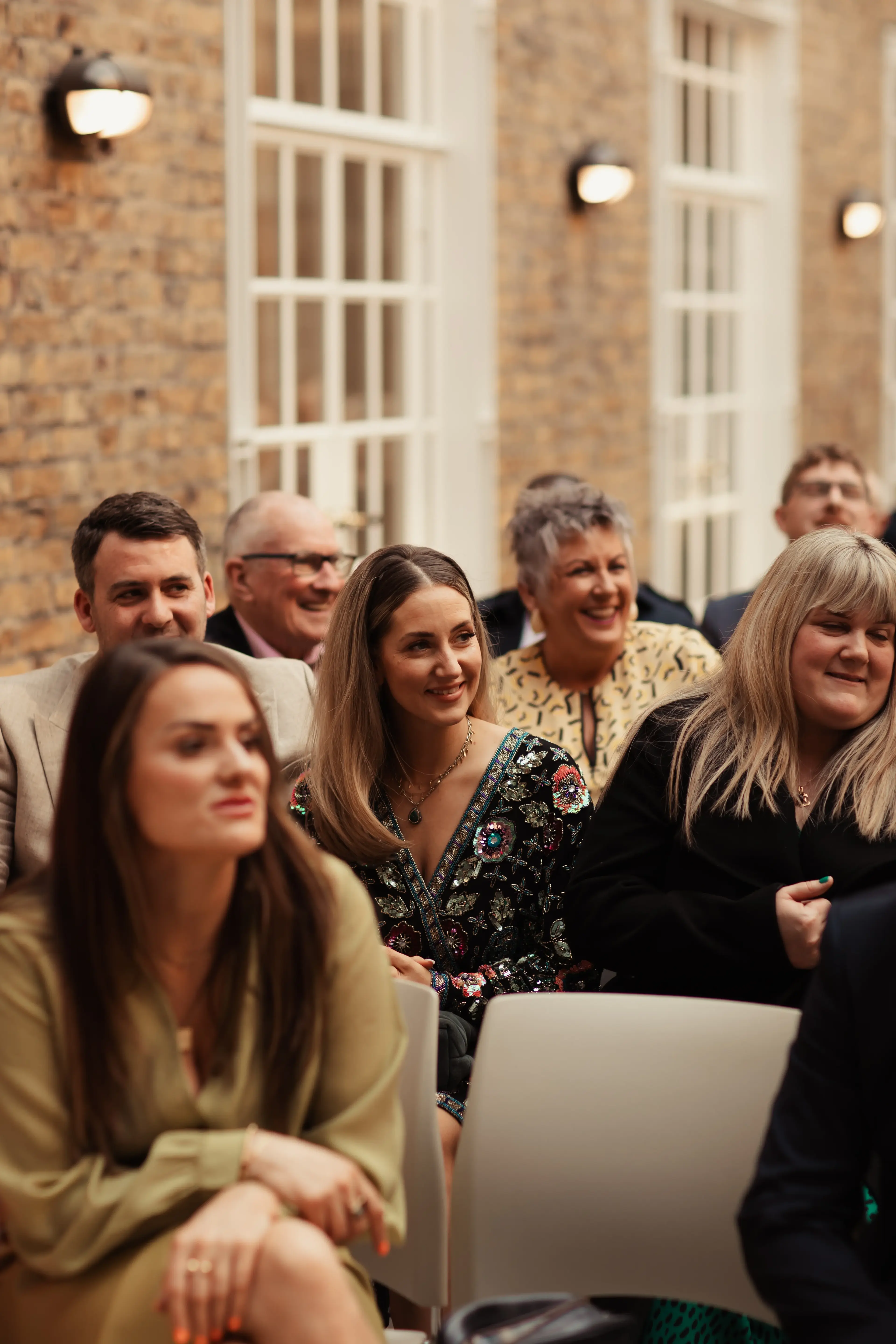 Wedding guests sat for a wedding ceremony inside Hackney Town Hall, London