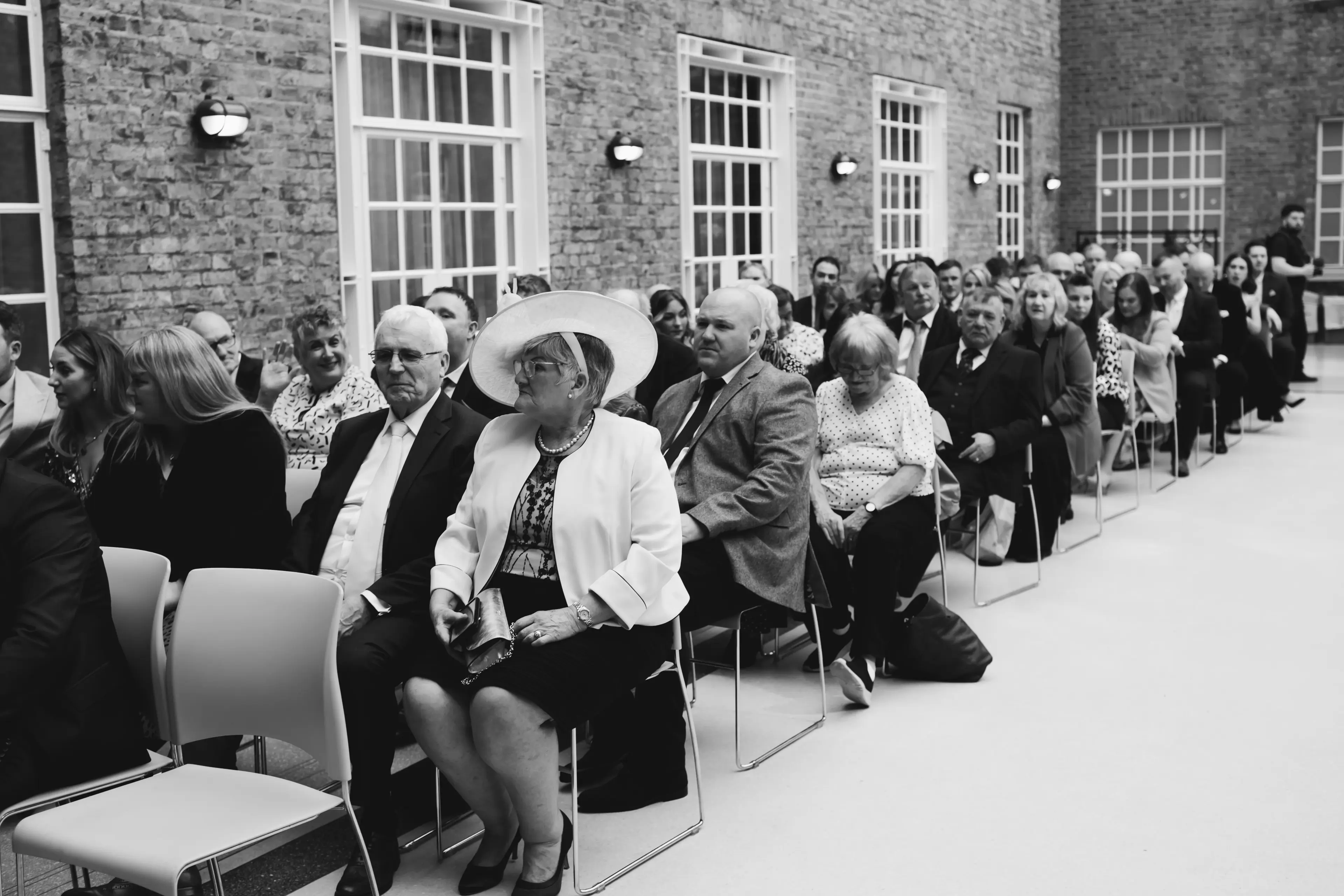 Wedding guests sat waiting before a ceremony inside Hackney Town Hall