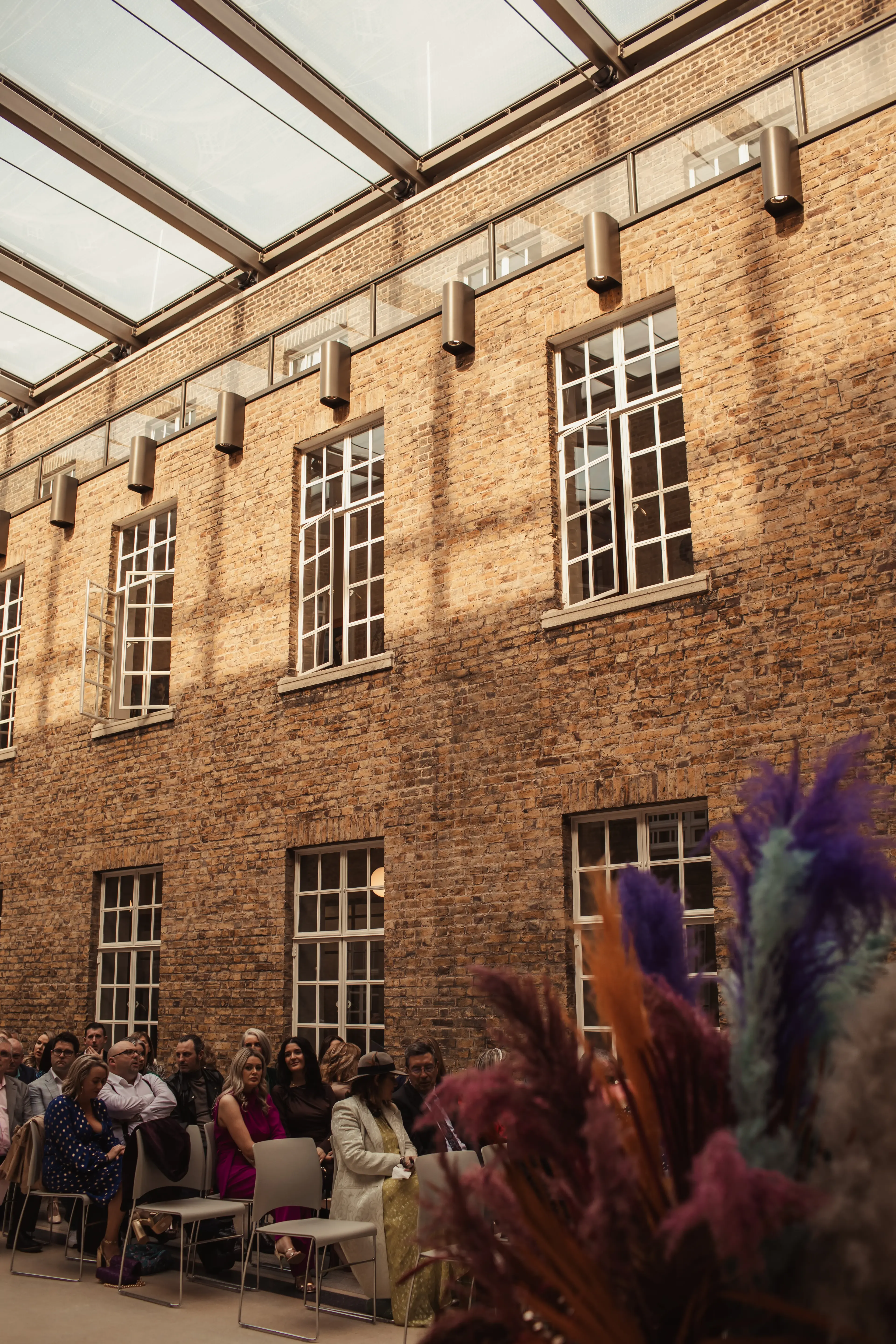 Guests sat behind some floral styling before a wedding ceremony in Hackney Town Hall, London