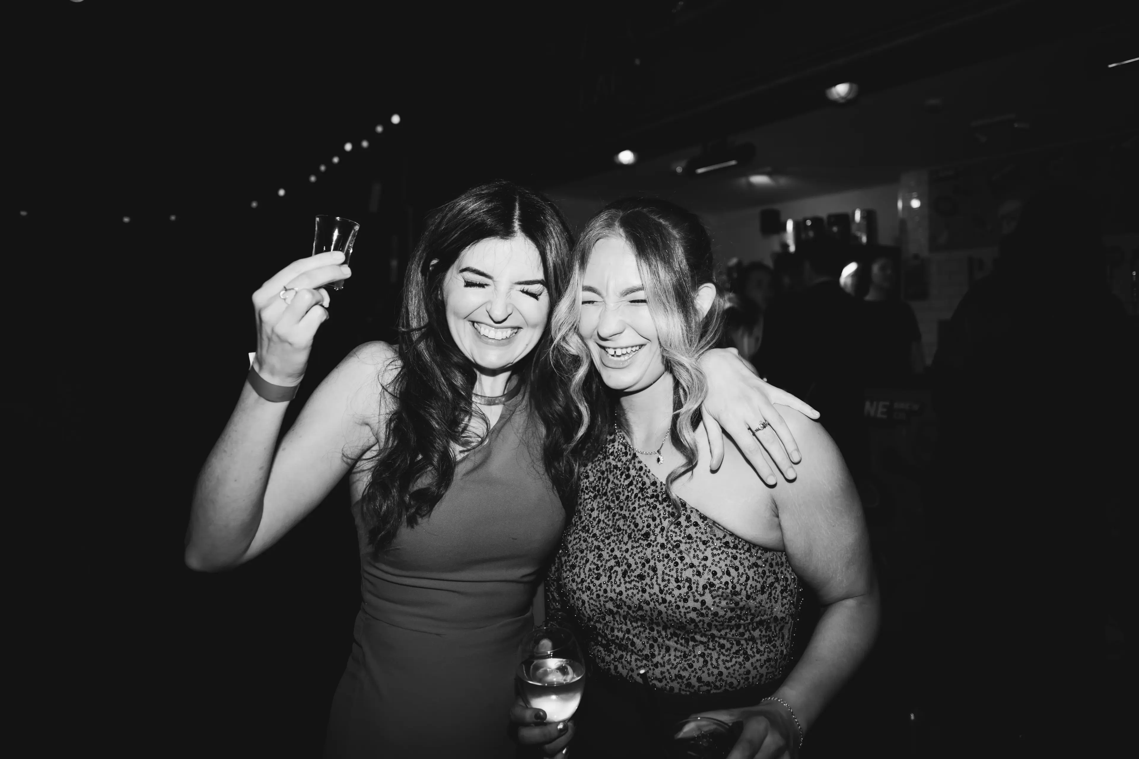 A couple of wedding guests drinking and laughing during a London pub wedding reception