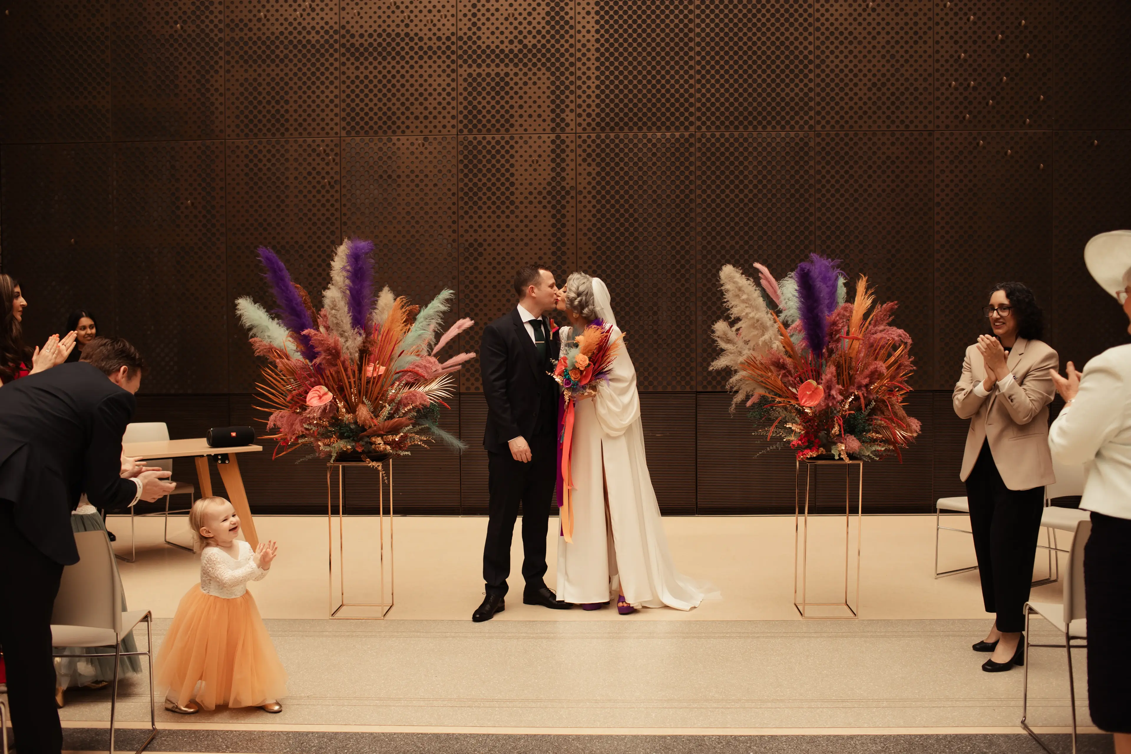 Newly married bride and groom share their first kiss inside Hackney Town Hall