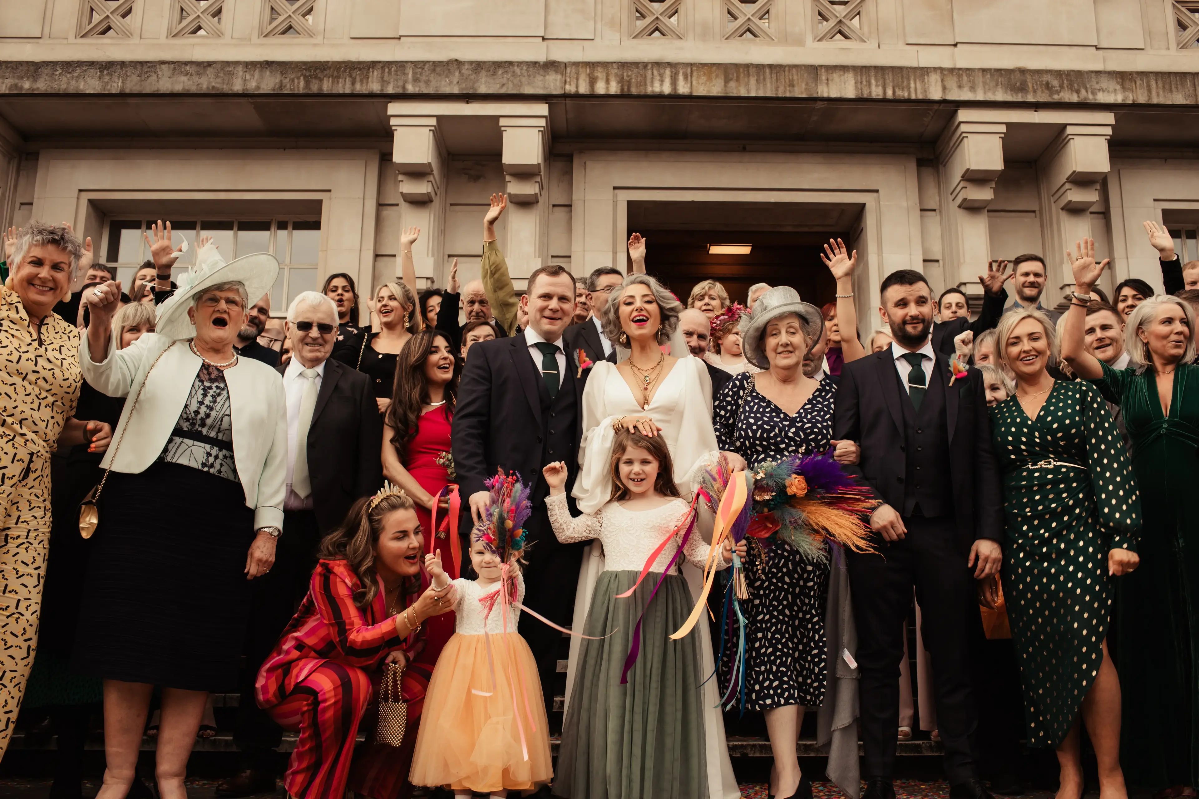 A wedding group shot with the newly married couple surrounded by friends and family at Hackney Town Hall, London